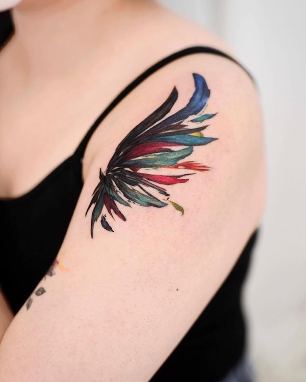 Tatuaj cu aripi pe partea superioara a bratului de catre @9room_tattoo