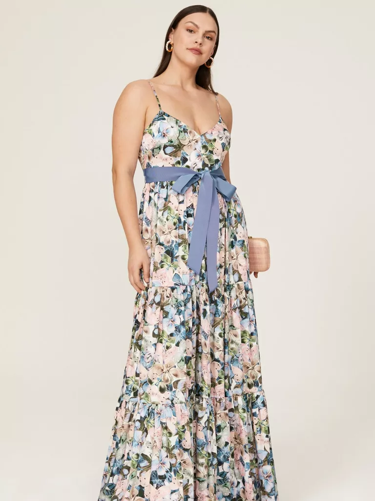 Modelul poarta o rochie maxi cu imprimeu de flori, cu o curea in talie.